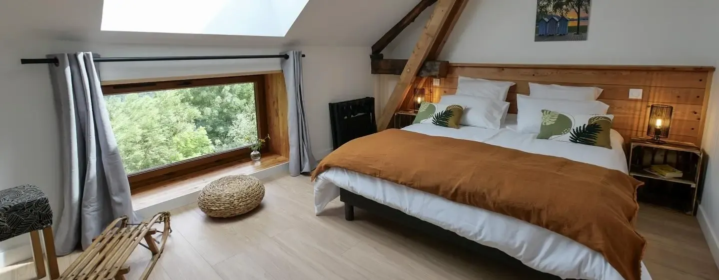 La chambre Pic Saint André, son lit double sous les poutres et sa fenêtre ouverte sur les arbres