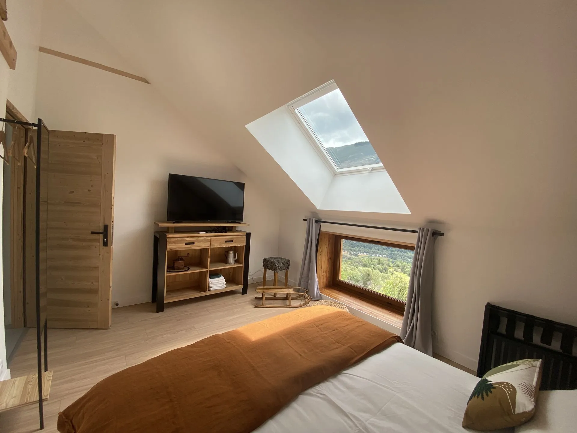 Une chambre mansardée du Couleau, avec son velux, sa télévision et sa fenêtre ouverte sur la vallée