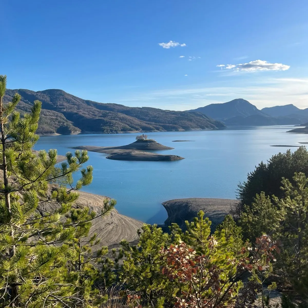 Le lac de Serre-Ponçon et la presqu'île de la chapelle Saint-Michel, sous un ciel dégagé