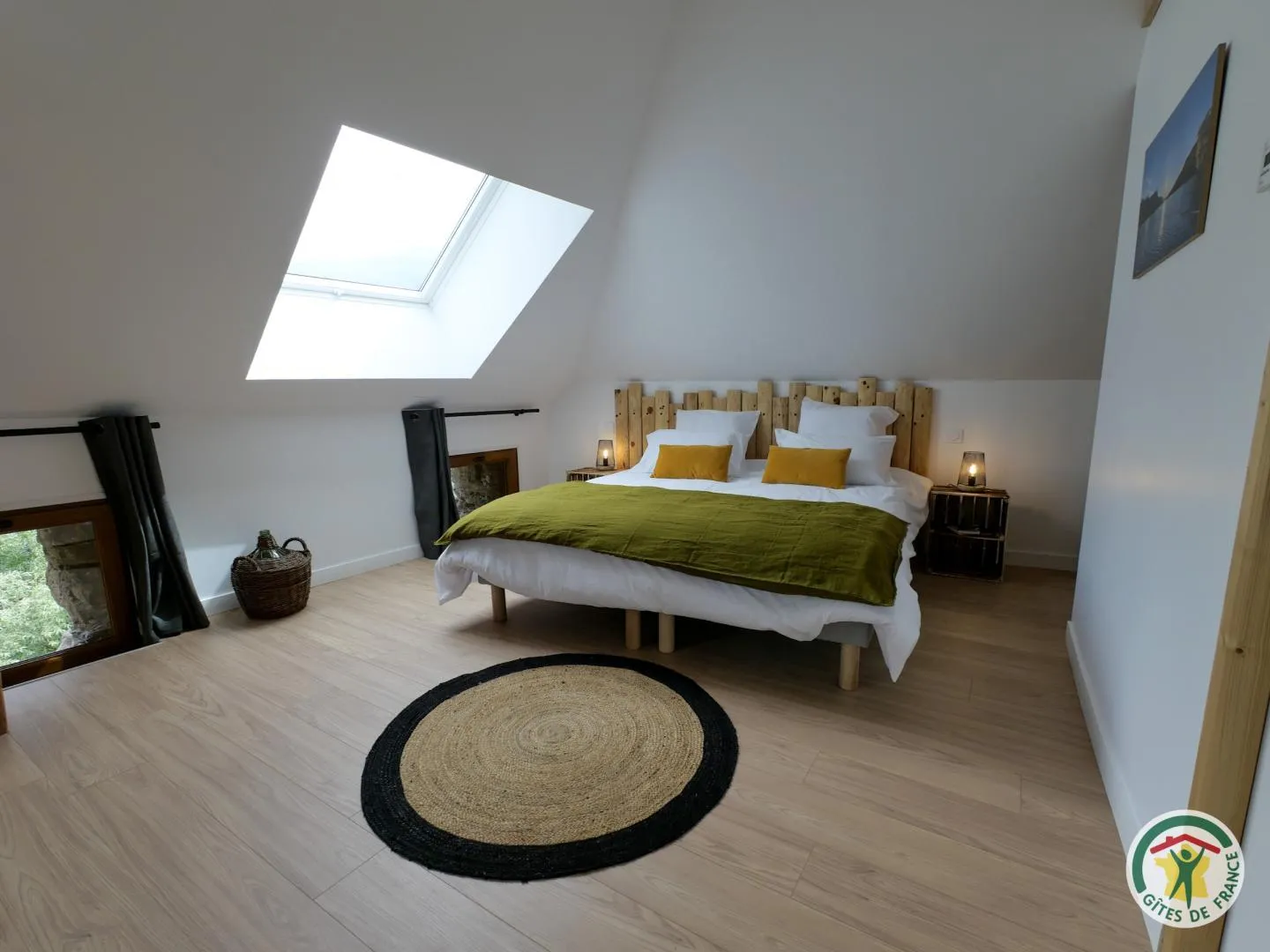 Le lit double de Pic du Clocher, sa tête de lit en rondins de bois et son tapis de jute rond