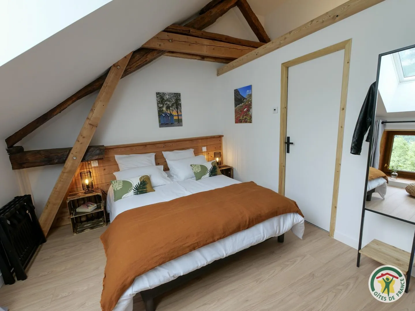 Vue d'ensemble de Pic Saint André, avec son lit double, sa tête de lit en bois et son miroir sur pied