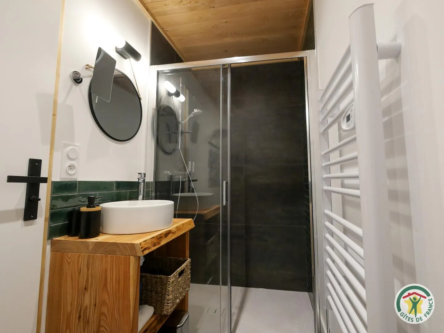 La salle de douche privative de Pic Saint André, habillée de faïence verte, avec sa vasque en céramique