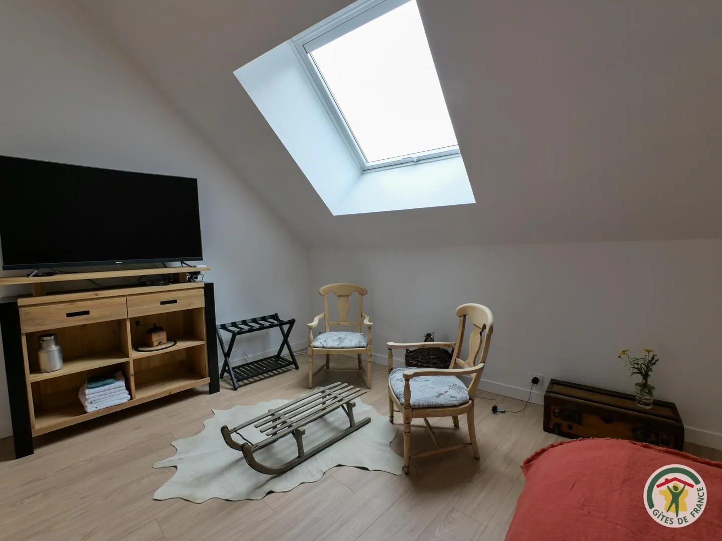 Le coin détente de Sous les étoiles, avec sa télévision, ses fauteuils anciens et sa luge en bois