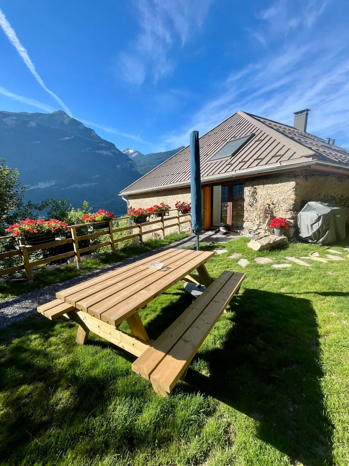 La terrasse du Couleau et sa grande table en bois, face aux sommets enneigés